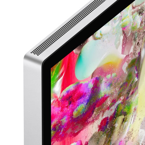 Silver Apple Studio Display showing vibrant multicolor abstract wallpaper with slim black bezel and perforated speaker.