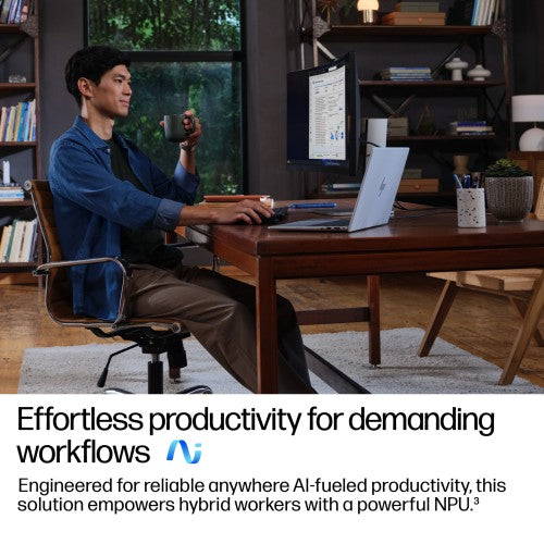 Silver HP EliteBook 14-inch laptop open on a wooden desk with touchscreen displaying software, man sitting and using mouse.