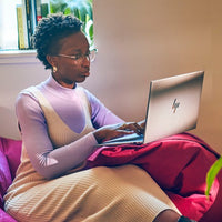 Silver HP ZBook Firefly G11 laptop with thin bezel on a person's lap, open display visible.